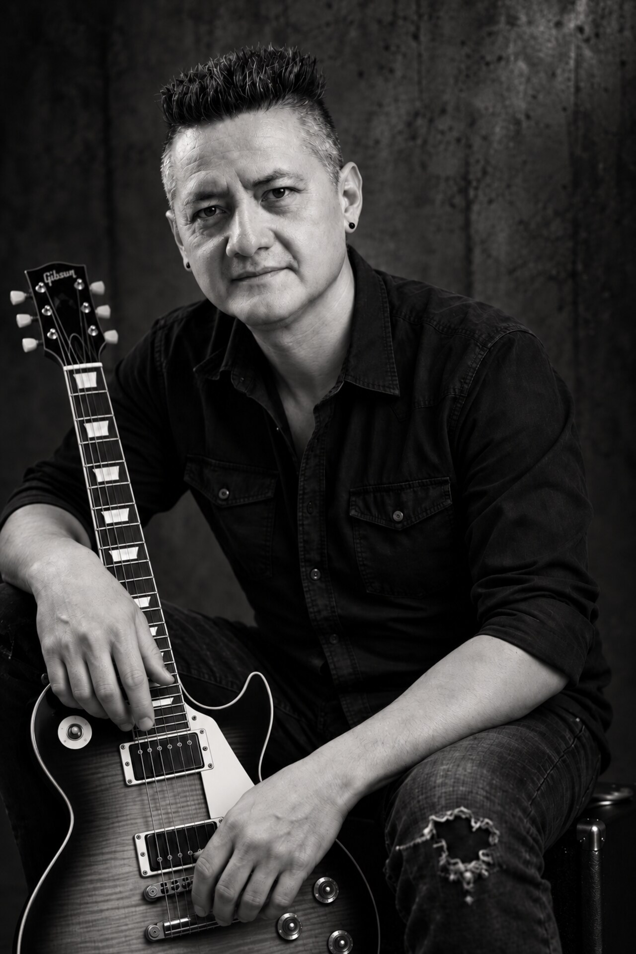 Guitarist Enrique Maya seated with an electric guitar